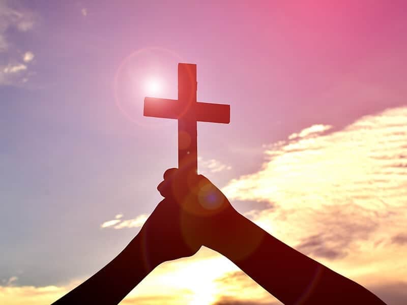 Faith Christian Cross Hands Sky Sun Glare credit Shutterstock