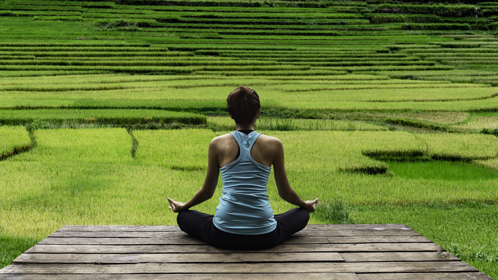 woman practicing yoga meditation during luxury yoga retreat in Asia Bali