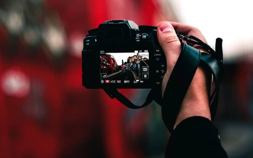 A photographer using the best camera for beginners to capture an image of a busy street