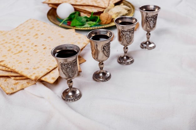 passover matzoh jewish holiday bread four glasses kosher wine wooden table